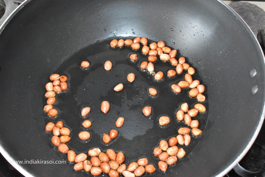 When the oil is hot, add raw peanuts to it