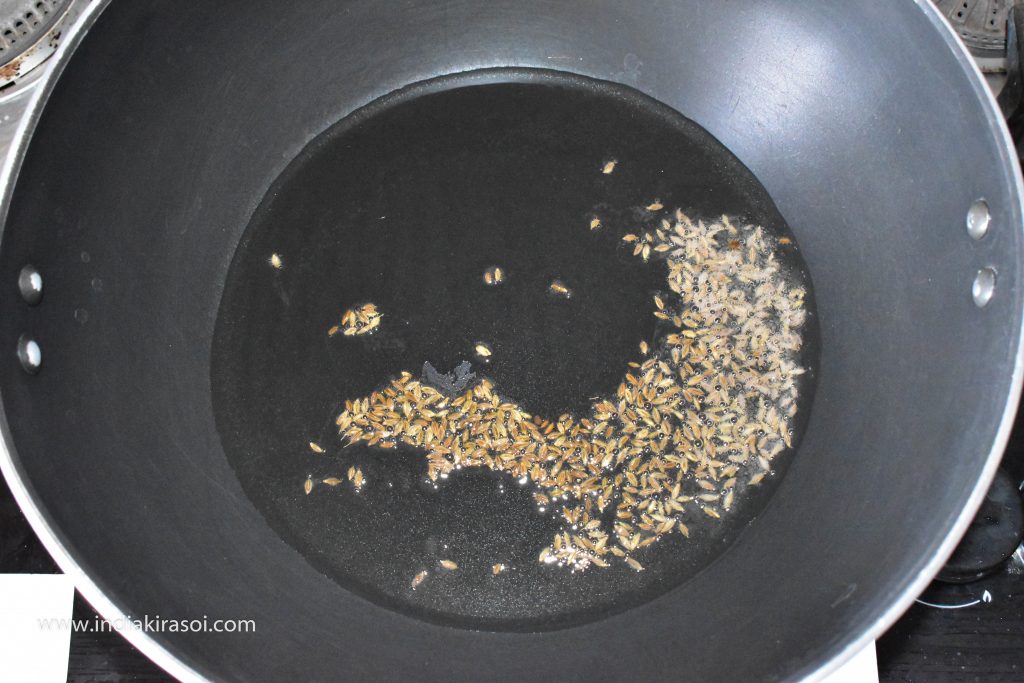 When the desi ghee or oil is hot, add cumin seeds in the kadai / pan.