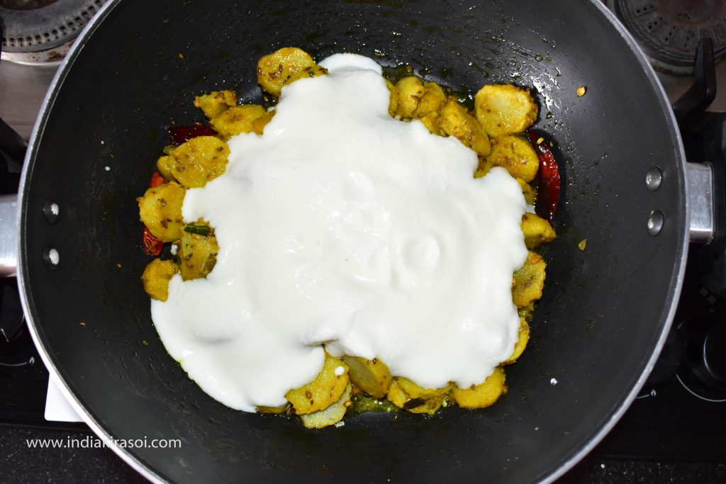 When the colocasia / arbi fries started to turn light brown. Then pour the whipped curd in the kadai / pan.