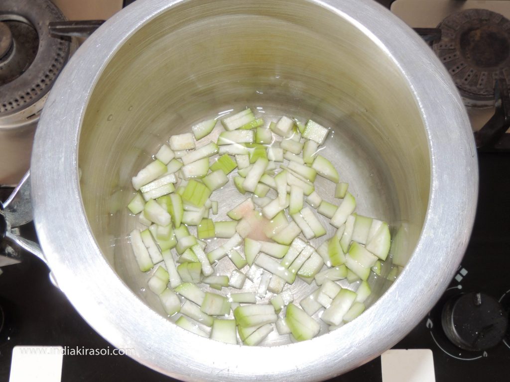 Pour the chopped Bottle gourd into the cooker and add half a cup of water.