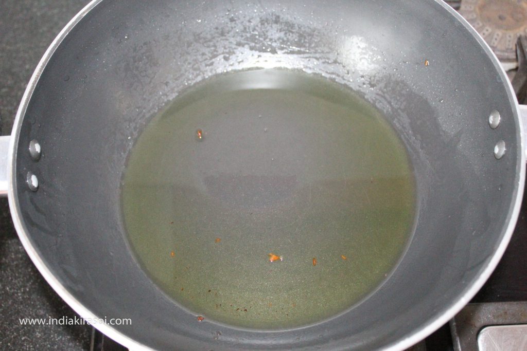Now take out the extra oil from the cauldron in which we made the dumplings. Leave 2 tablespoons of oil left in the pan.