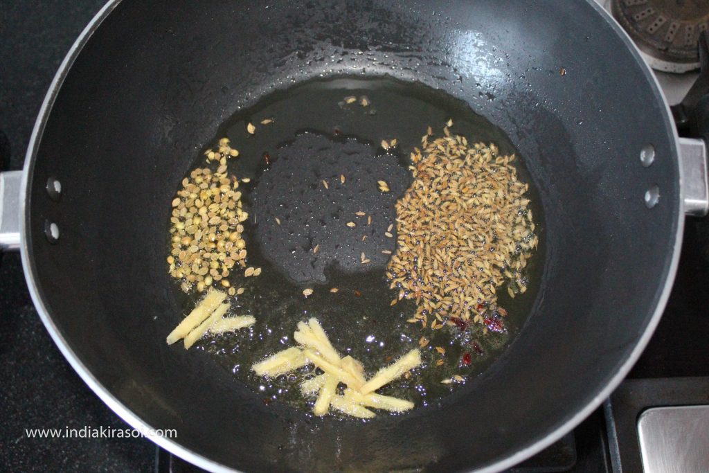 When the oil is hot, add one teaspoon of cumin seeds to the oil, along with chopped ginger, add 2 to 3 crushed cloves, half teaspoon coarse coriander seeds.