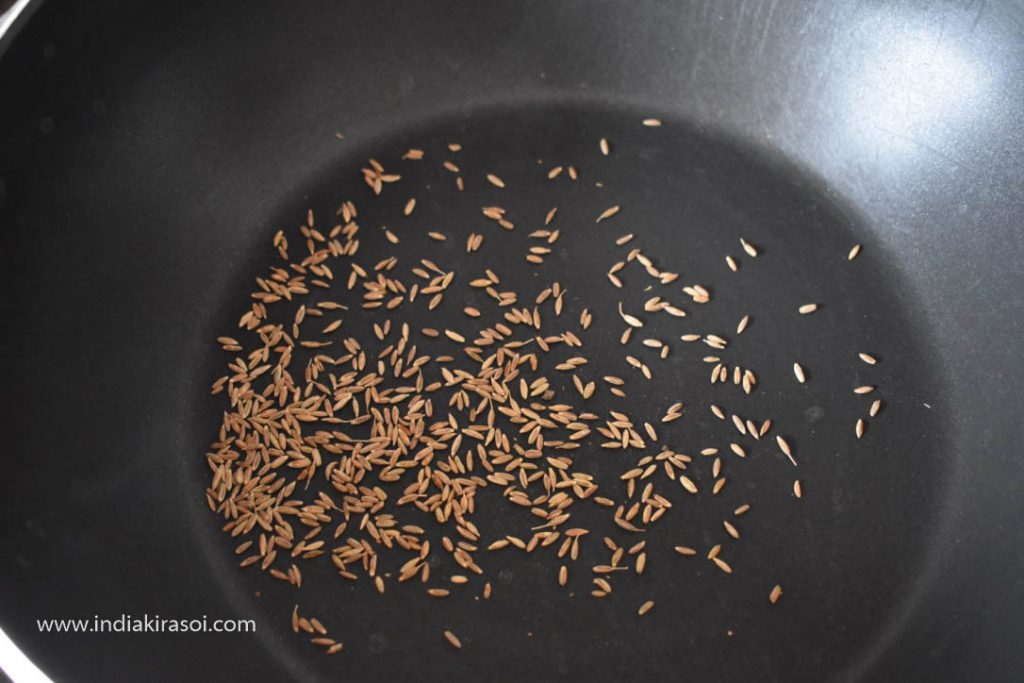 Fry the cumin seeds with a spoon.