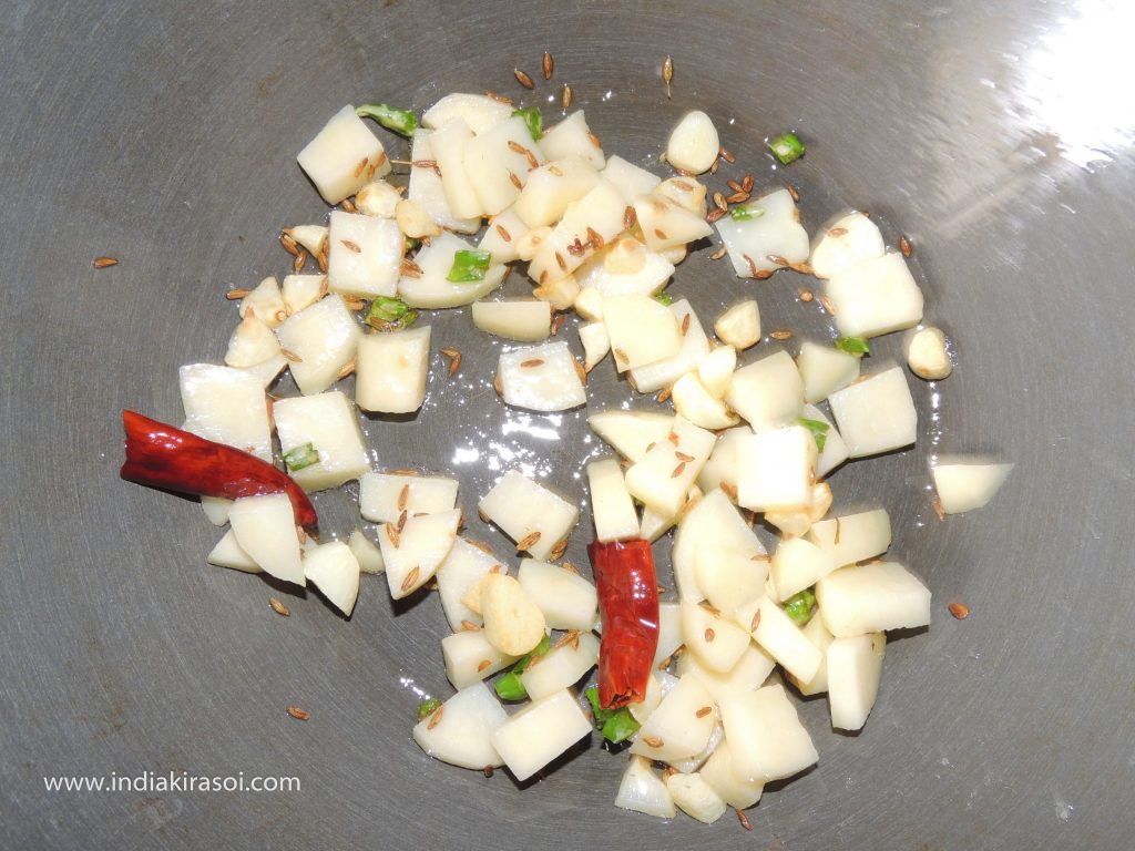When cumin starts crackling, add chopped potatoes in the pan.