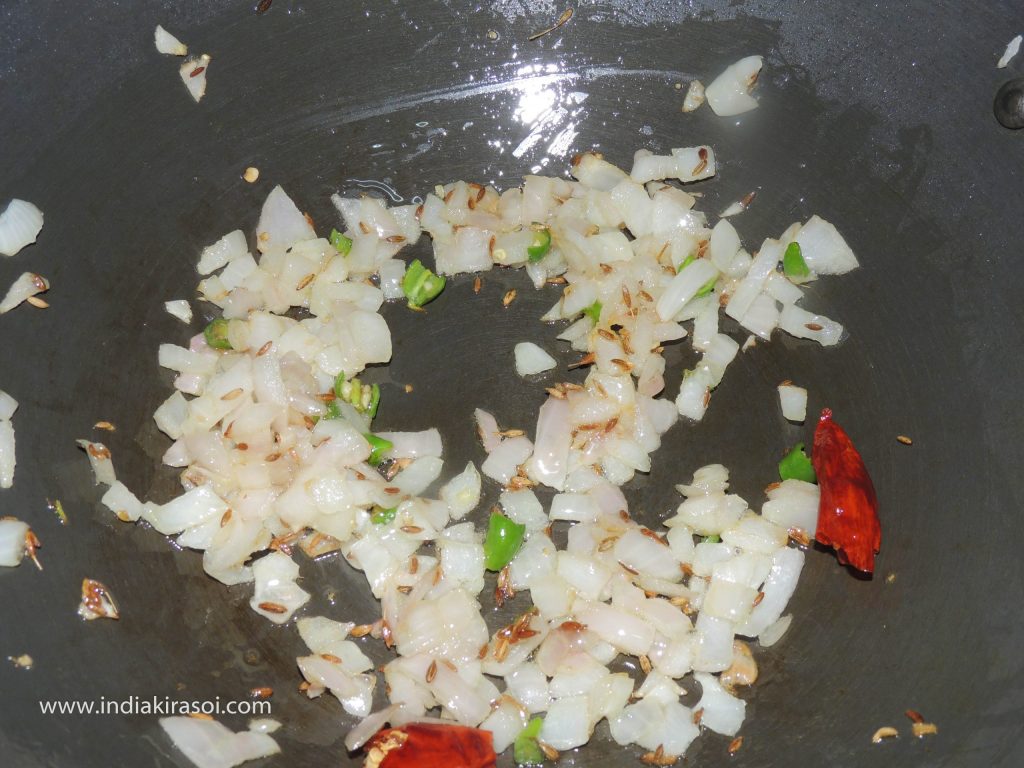 When the onion is fried, add chopped potatoes in the kadhai/fry.