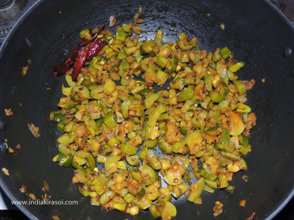 After 3 minutes remove the plate from the kadhai/ frying pan and mix the pointed gourd/ parwal with a spatula.