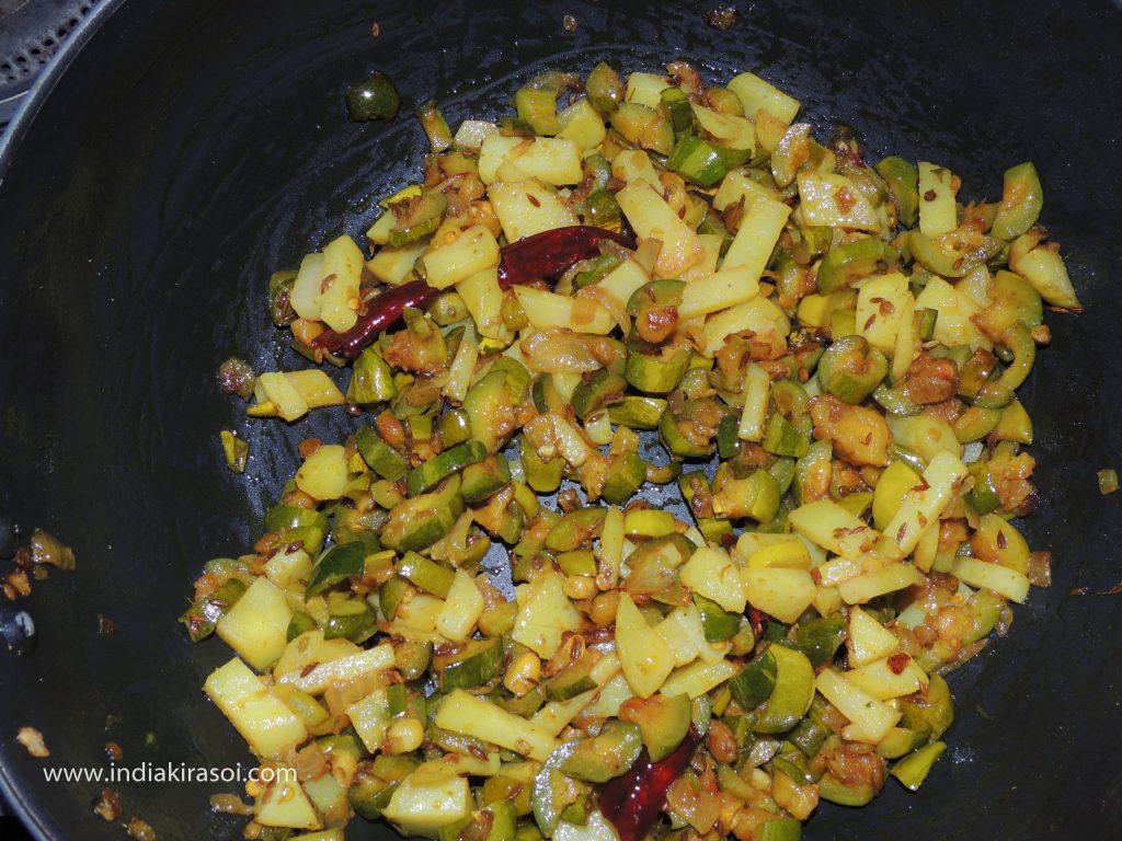 If the pointed gourd/ parwal is cooked, put fried potatoes in the kadhai/ frying pan.