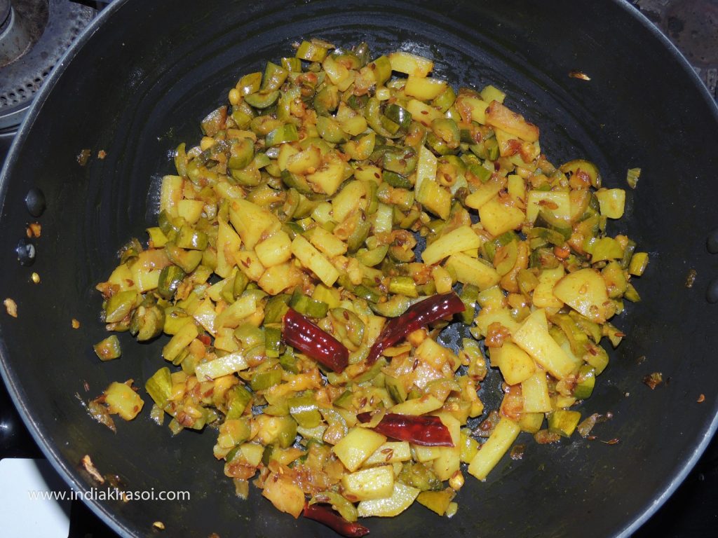 If the pointed gourd/ parwal is cooked, put fried potatoes in the kadhai/ frying pan.