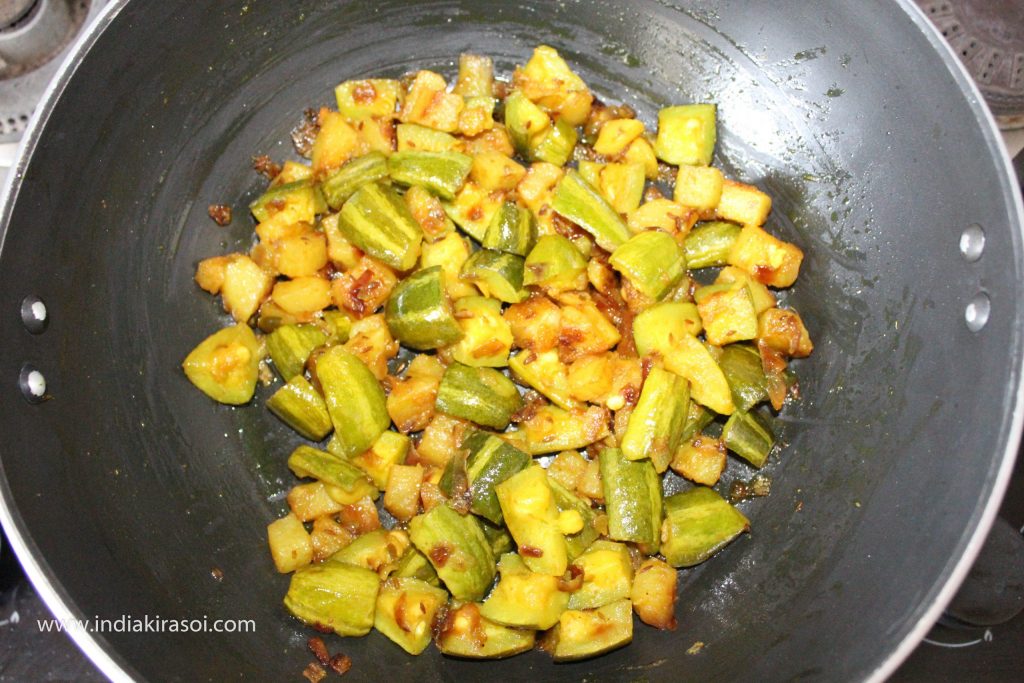 Cook the pointed gourd/ parwal for 5 to 6 minutes, removing the plate from the kadhai/ fry pan, stirring occasionally so that the pointed gourd/ parwal does not burn.