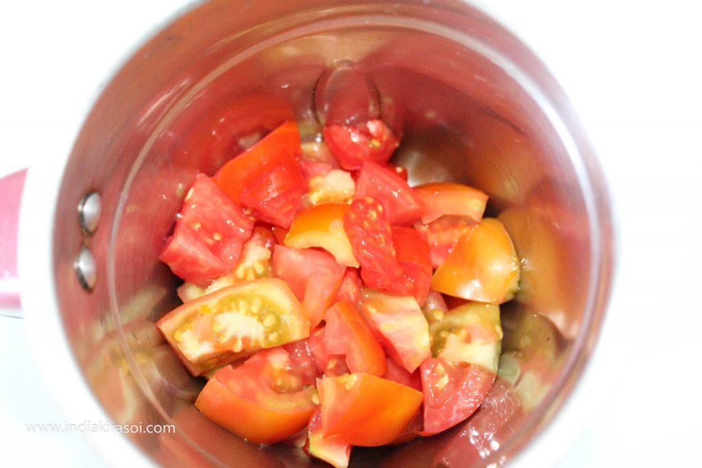 Take 3 tomatoes and chop the tomatoes, then add the chopped tomatoes to the jar of the mixer grinder.