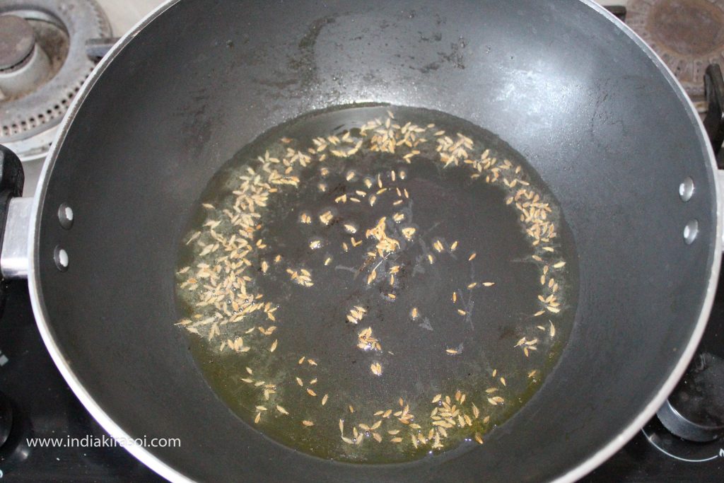 When the oil is hot, add one teaspoon of cumin seeds to the oil.