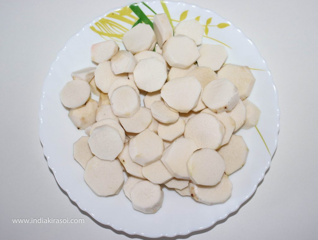 Cut the colocasia / arbi or ghuiyan into round slices.
