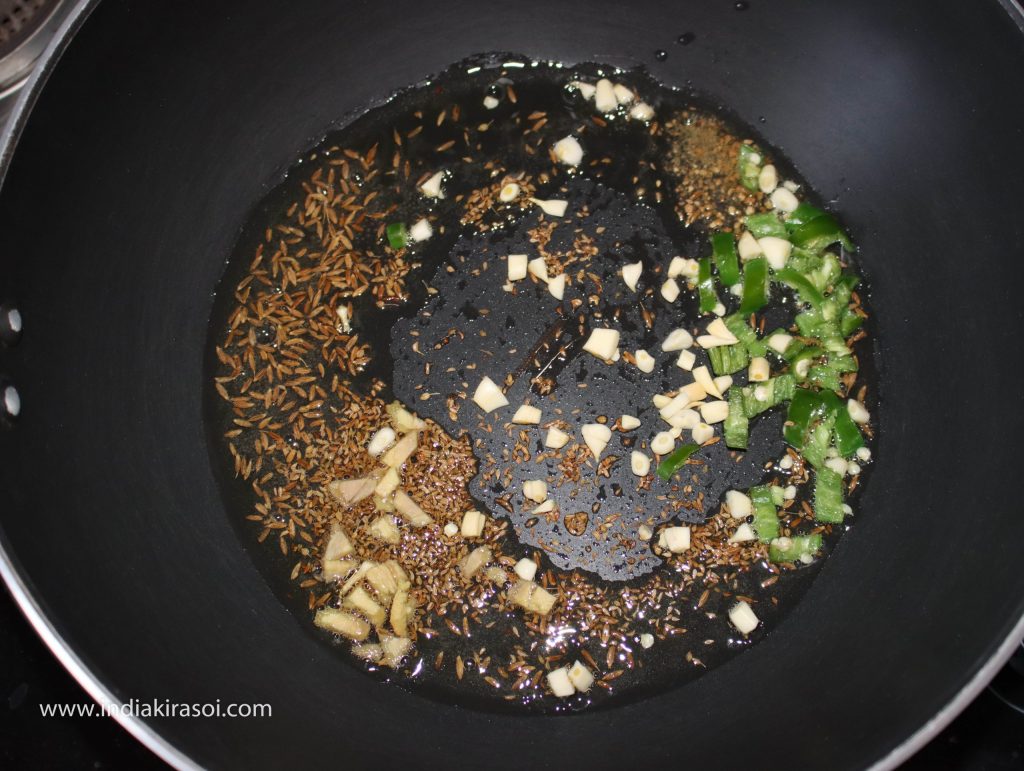 Add chopped green chili, garlic, ginger to the kadhai/ fry pan.