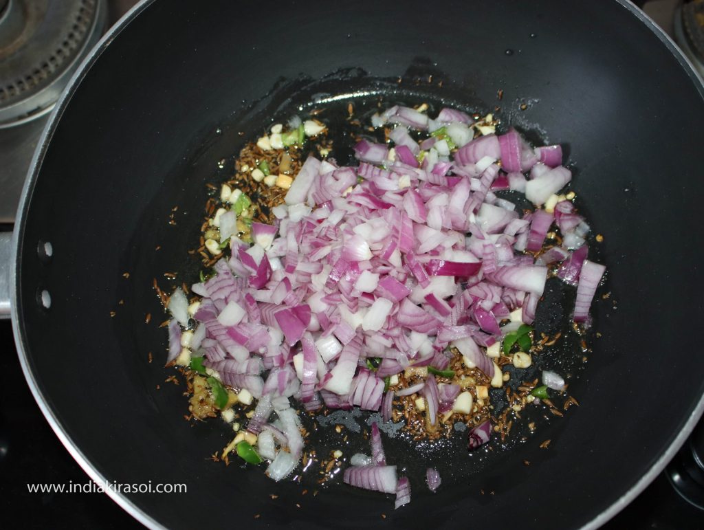 Add finely chopped onion in kadhai/ fry pan once the ginger and garlic are fried. Fry the onion.