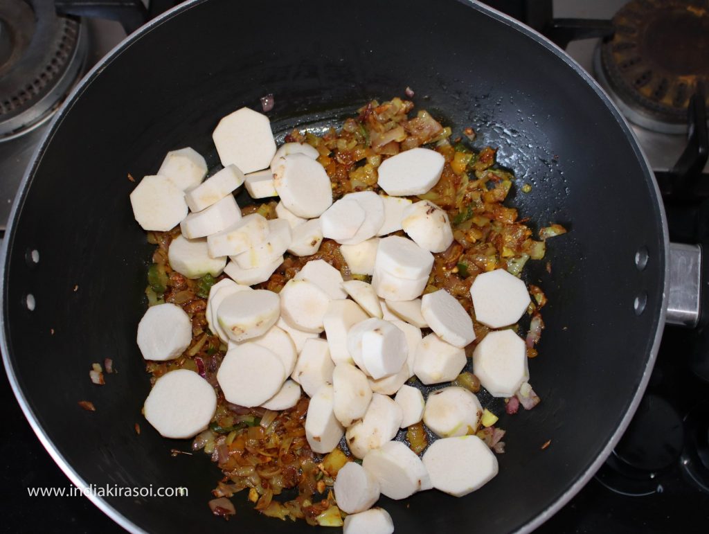 After this, add chopped colocasia / arbi or ghuiyan in the kadhai/ fry pan.