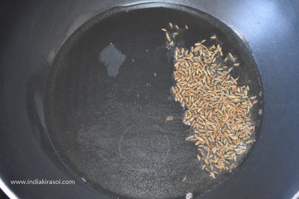 When the oil is hot, add half a teaspoon of cumin seeds to the oil.