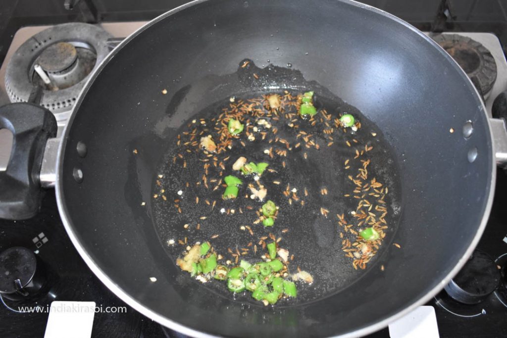 After this put the chopped green chilies in the kadhai/ fry pan and fry.