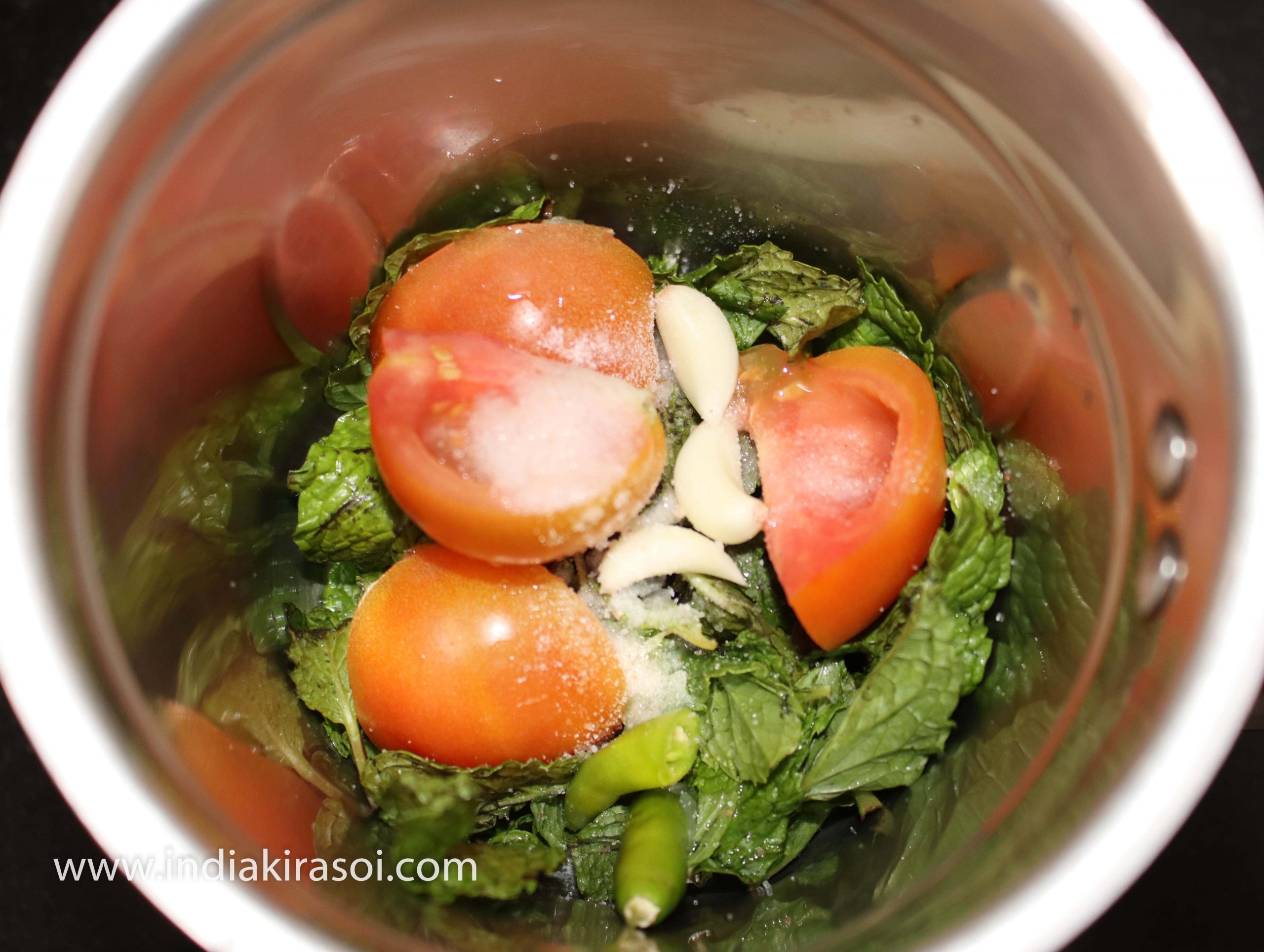 Cut the tomatoes and put in the jar of the mixer grinder, add green chili, mint, lemon juice, and salt to taste. You can also use black salt if you want.